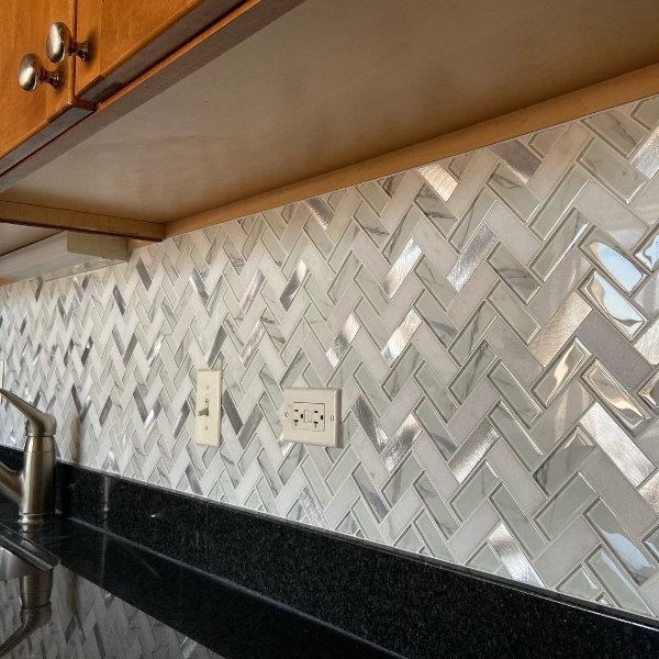 black granite kitchen counter with herringbone backsplash