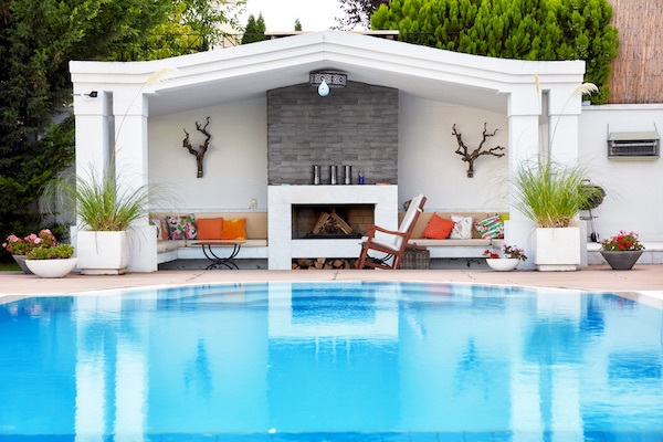 outdoor fireplace with stacked stone and pool