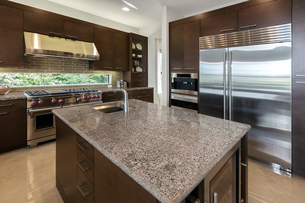 msi-arctic-sand-granite-kitchen-counter-with-brown-cabinets-min