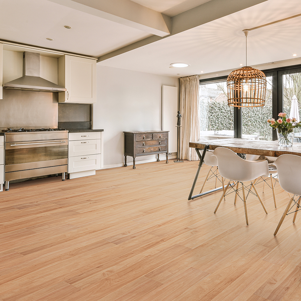 Open-concept kitchen with light wood-look vinyl plank flooring, comparing glue down vs floating vinyl plank flooring for large spaces.