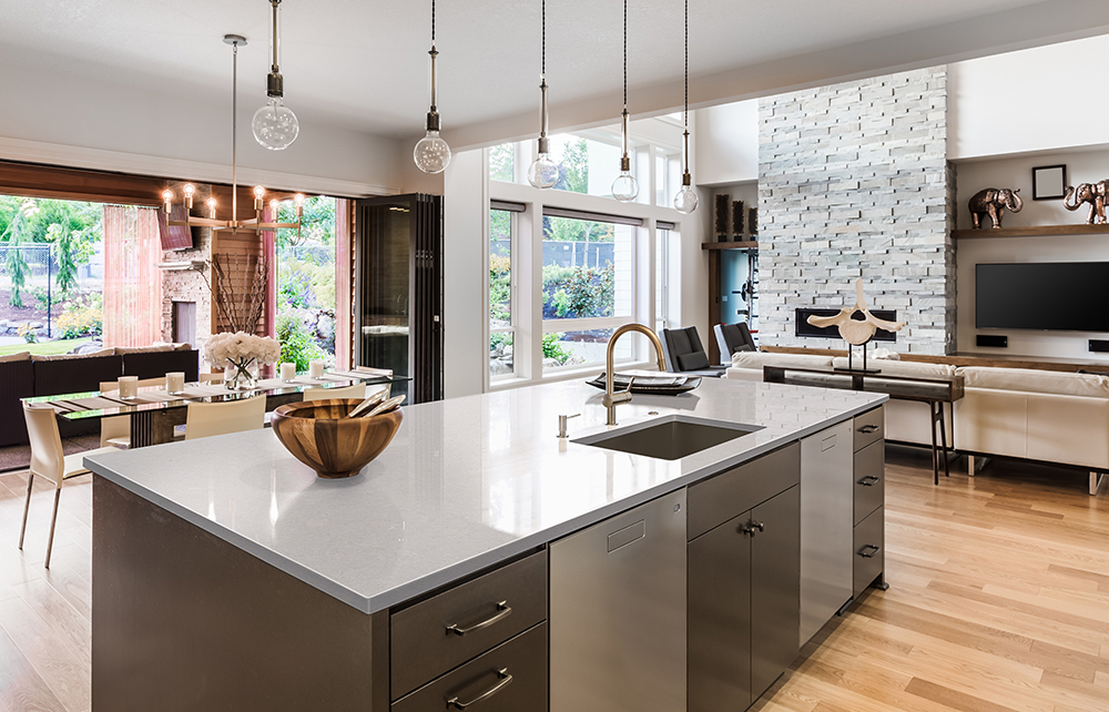 White quartz countertop island in an open-concept living space, showcasing one of the most popular quartz countertop color trends.