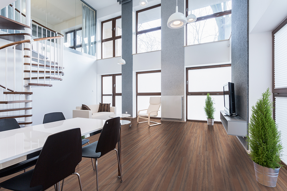 Dark wood-look LVT flooring in a modern living room, showcasing the enduring performance of quality LVT wear layer thickness.