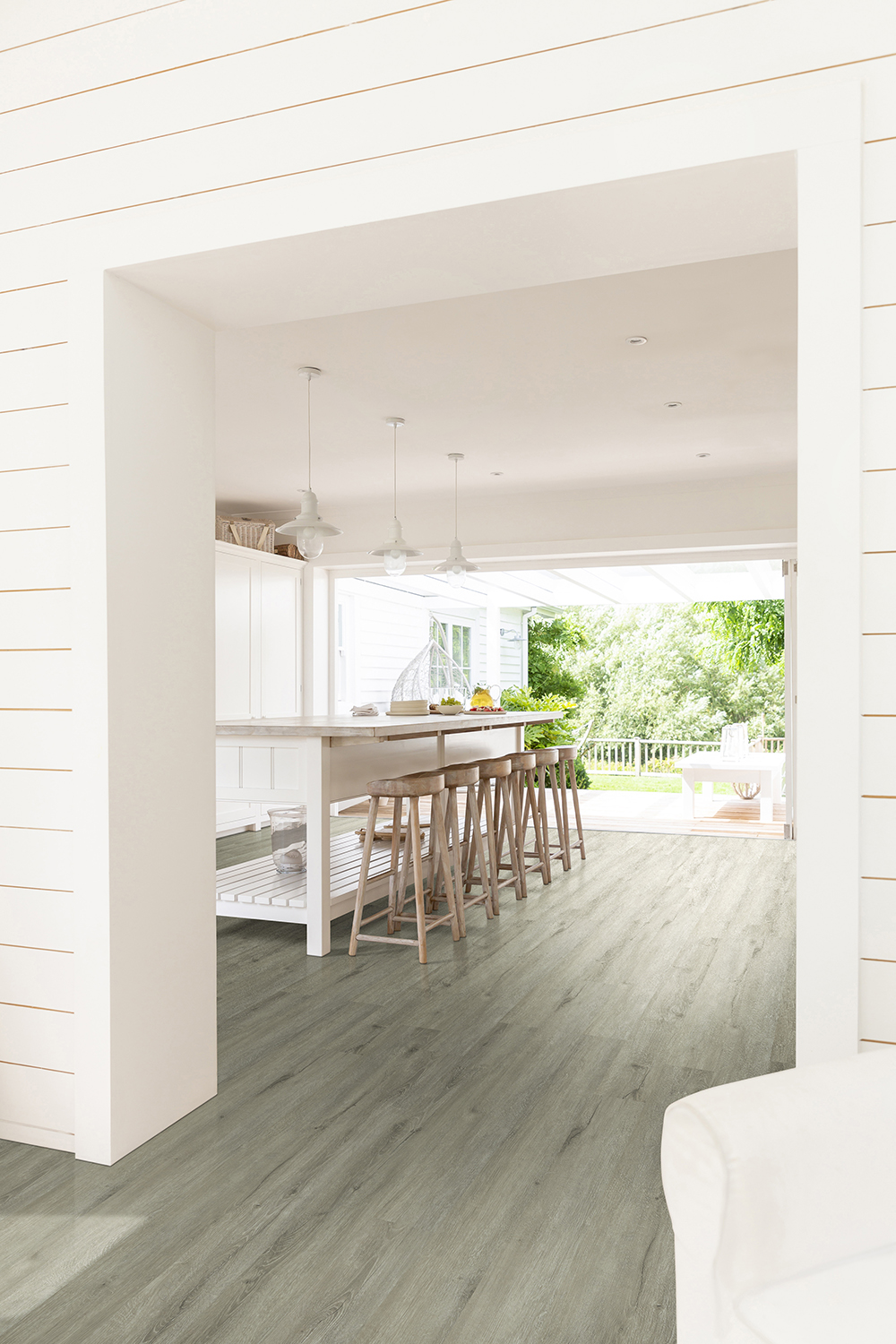 Open concept kitchen with durable gray wood look LVT flooring with LVT protective wear layer thickness.