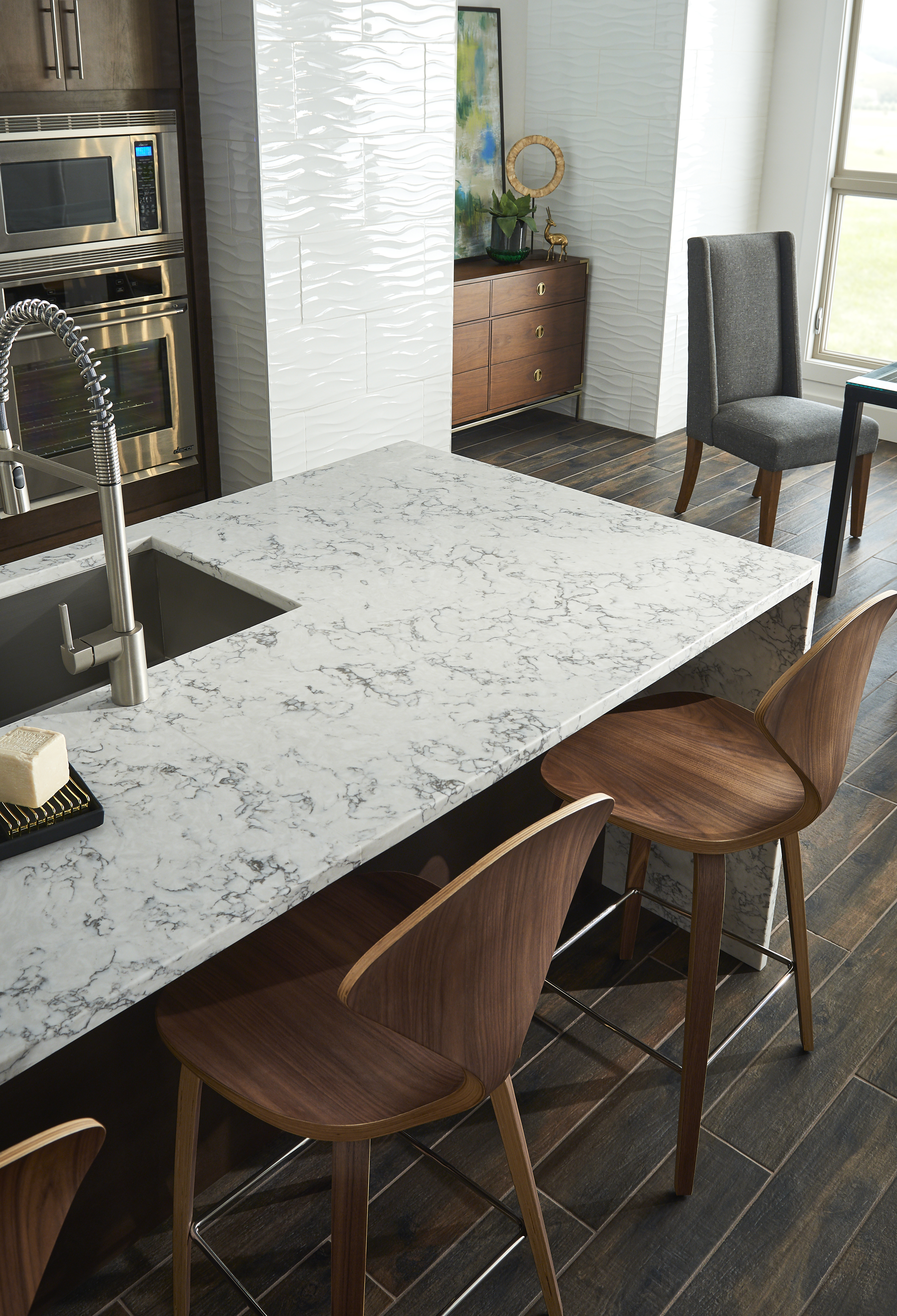 White marble-look quartz countertops with gray veining and a waterfall edge, showcasing a premium kitchen design that influences quartz countertops cost.