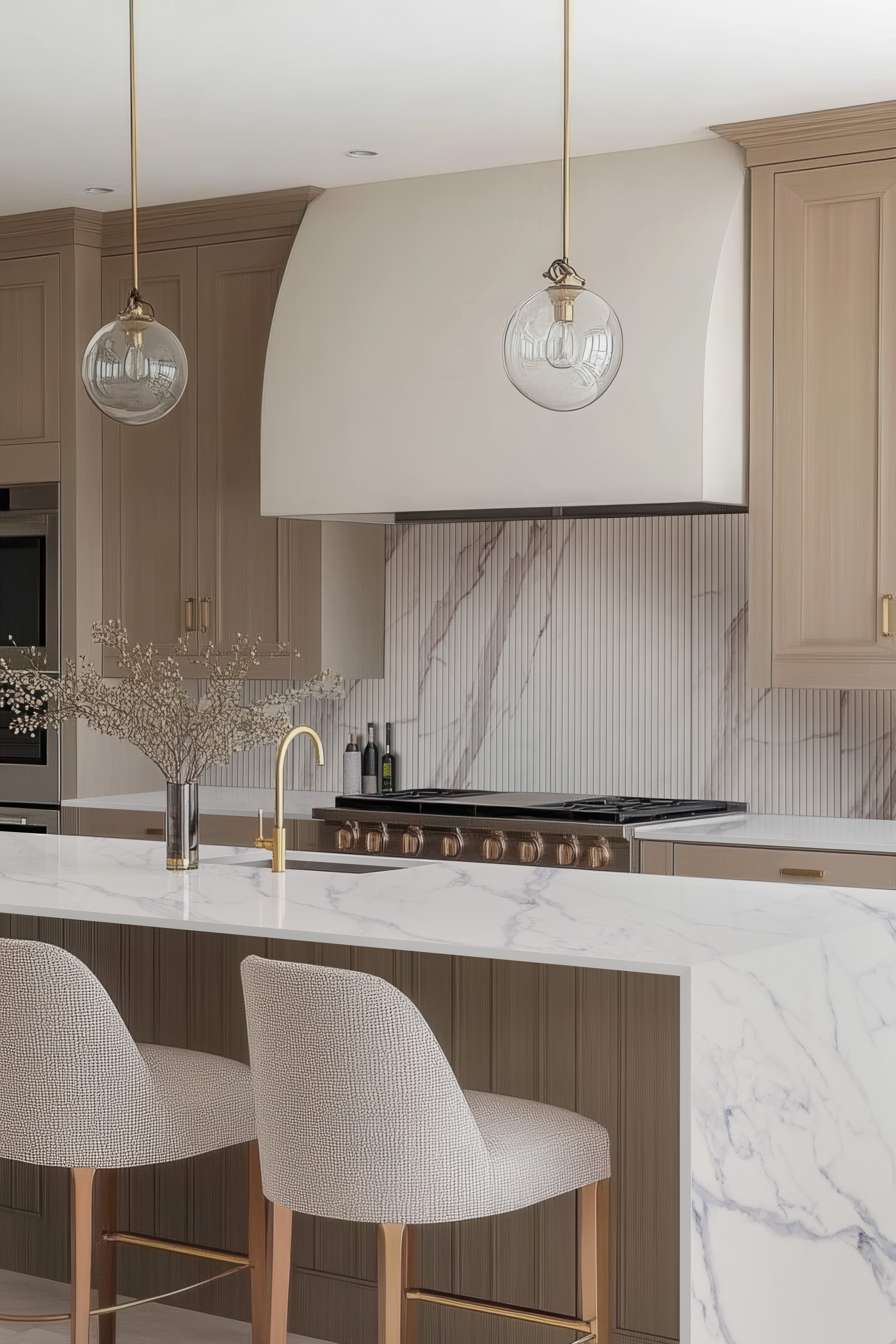 Modern kitchen with veined quartz countertops and waterfall island, illustrating factors that impact quartz countertop costs.