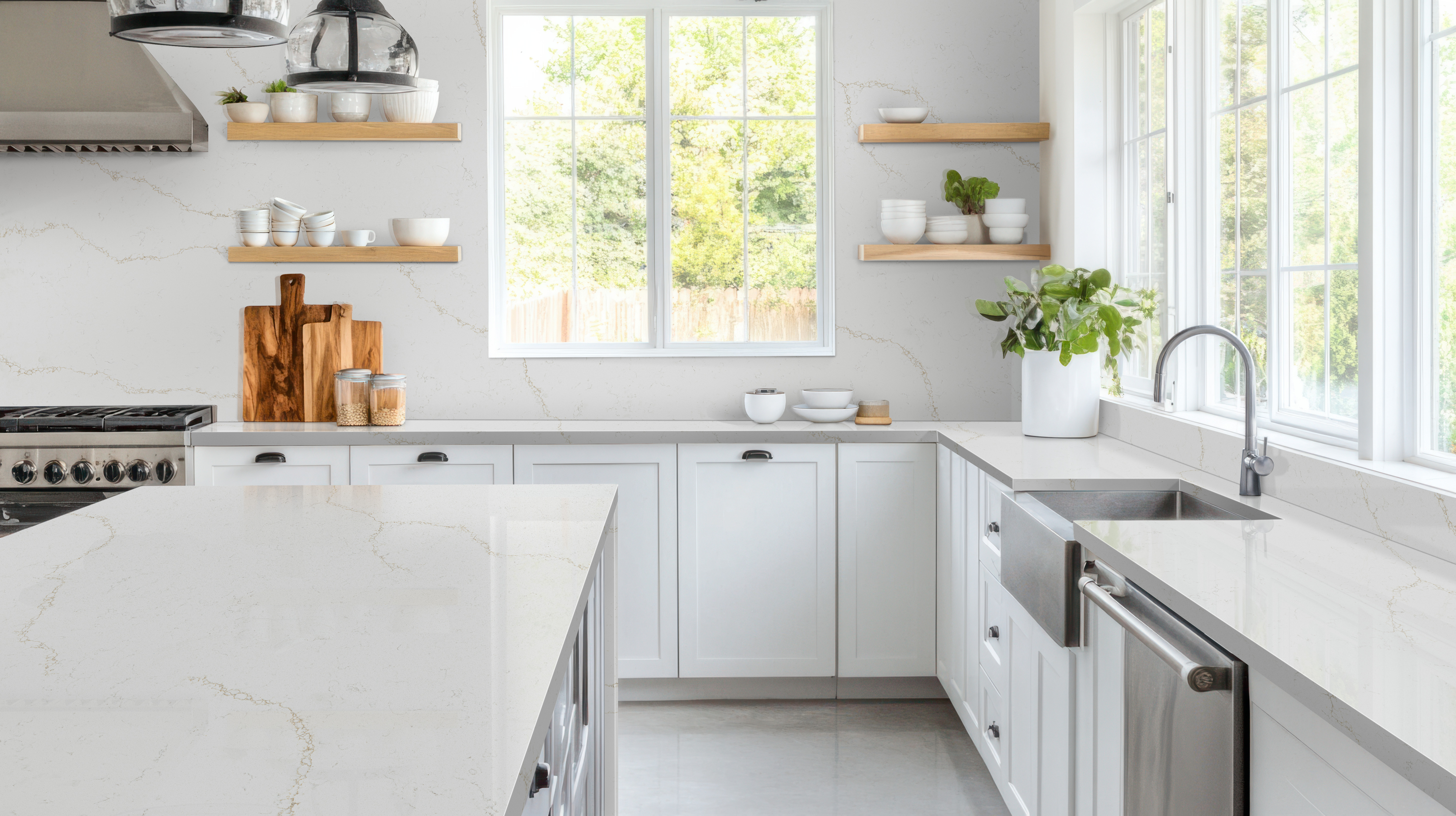White quartz countertops in a bright kitchen with farmhouse sink, showcasing a popular style for homeowners comparing quartz countertops cost.
