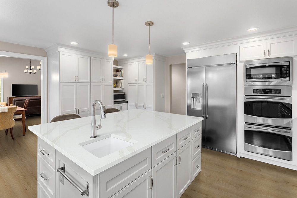 Bright kitchen with white quartz countertops and integrated island showing conventional quartz countertop thickness for residential applications.