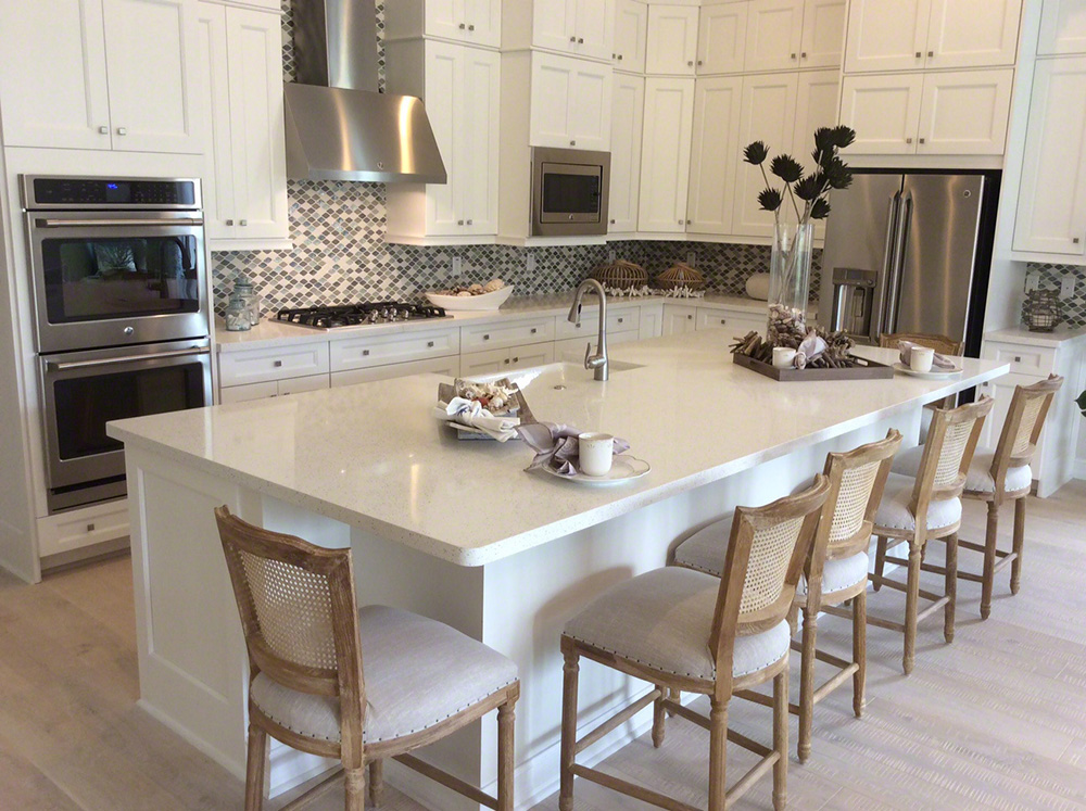 Large white quartz kitchen island demonstrating quartz countertop thickness in a spacious residential kitchen.