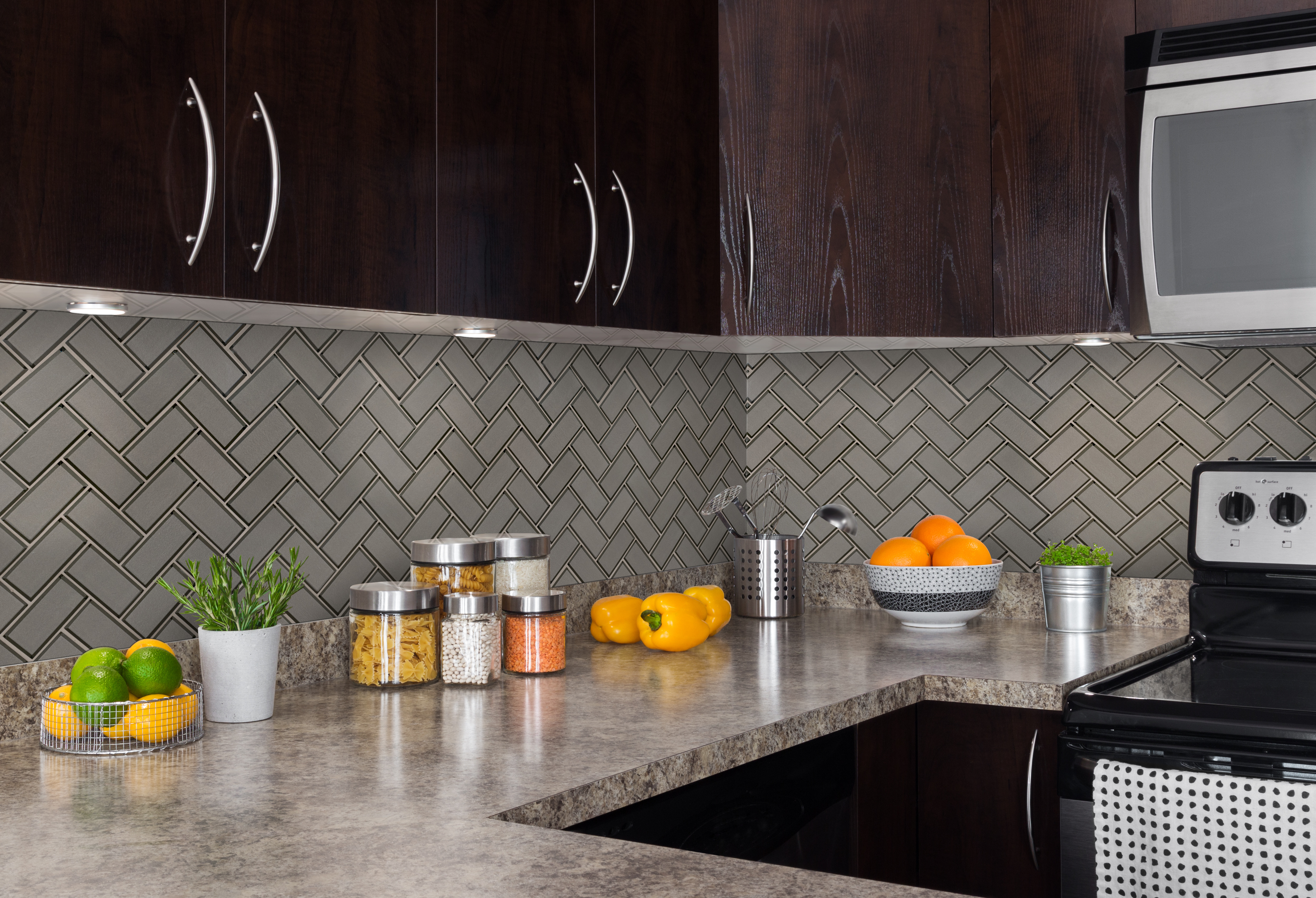 Champagne Bevel Herringbone backsplash with an example of how to finish edges of tile with a color-matched caulk where tile meets drywall.