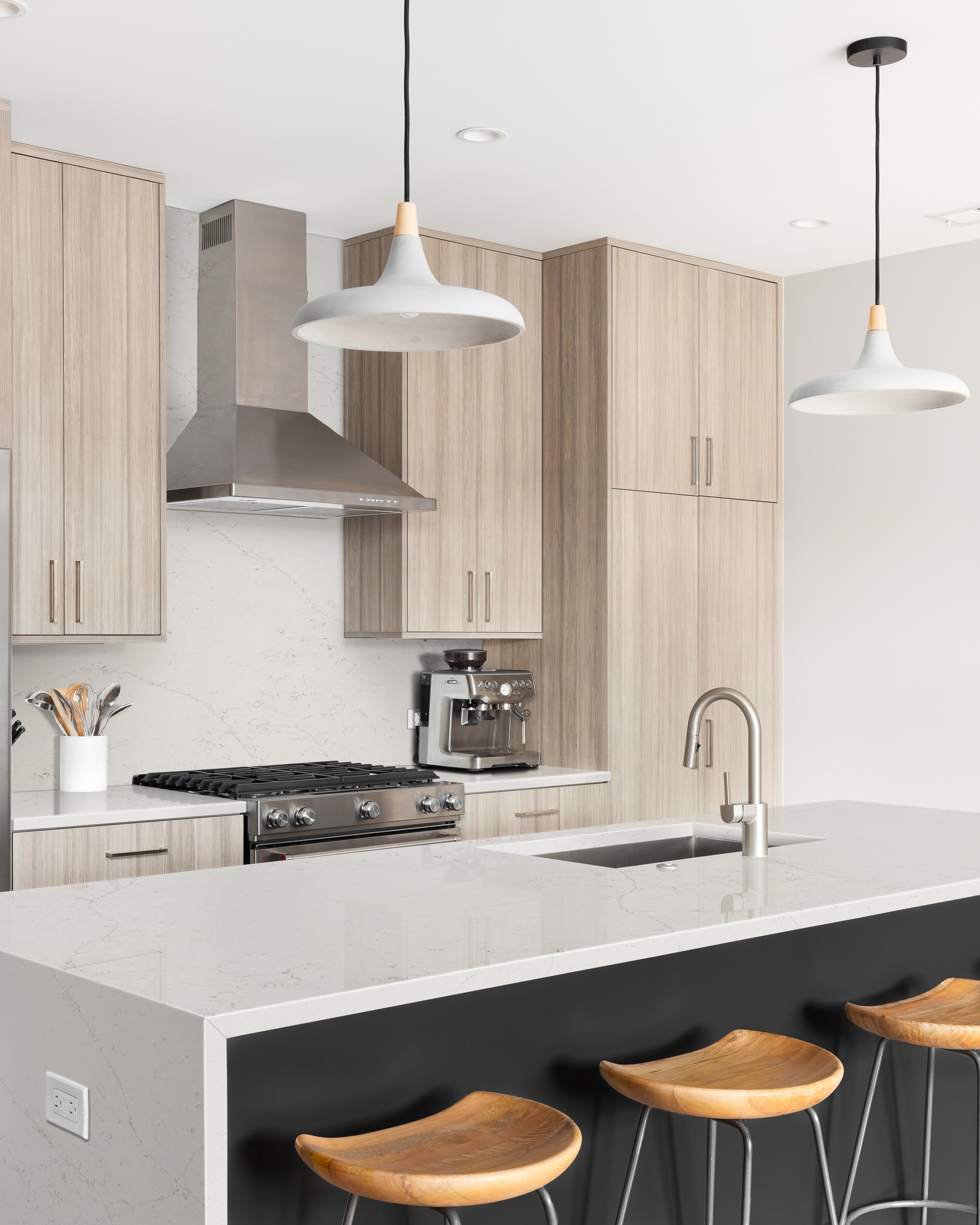 Waterfall quartz countertop with a thick edge profile, illustrating quartz countertop thickness in a modern kitchen.