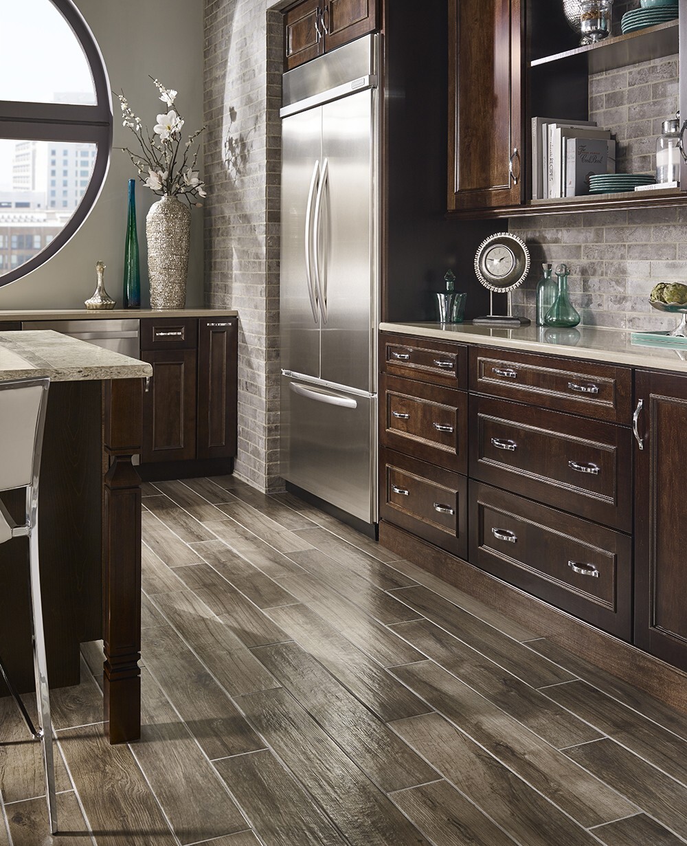 Rustic kitchen with a neutral stone tile backsplash, demonstrating the best tile for backsplash in kitchen designs with dark cabinetry.