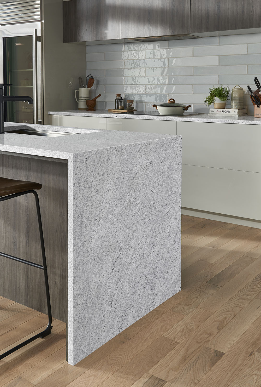 Waterfall granite countertop with a thick edge profile, showcasing granite countertop thickness in a contemporary kitchen.