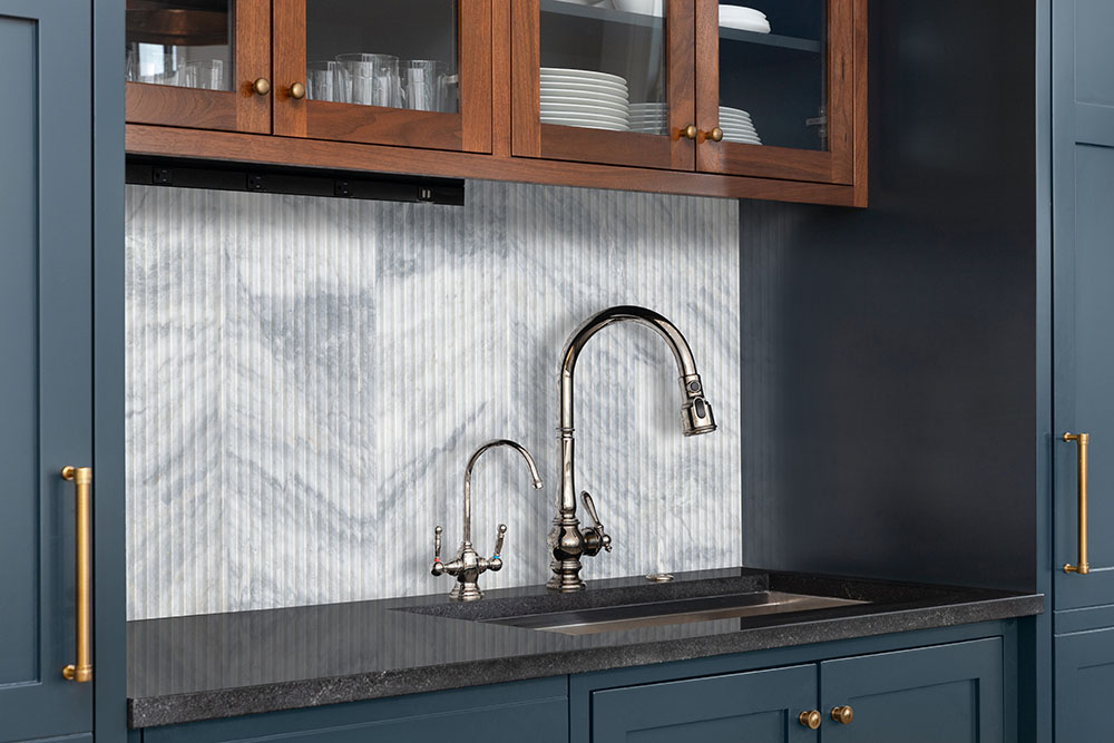Granite countertop and fluted stone backsplash with an integrated prep sink, exhibiting granite countertop thickness in a useful workflow.