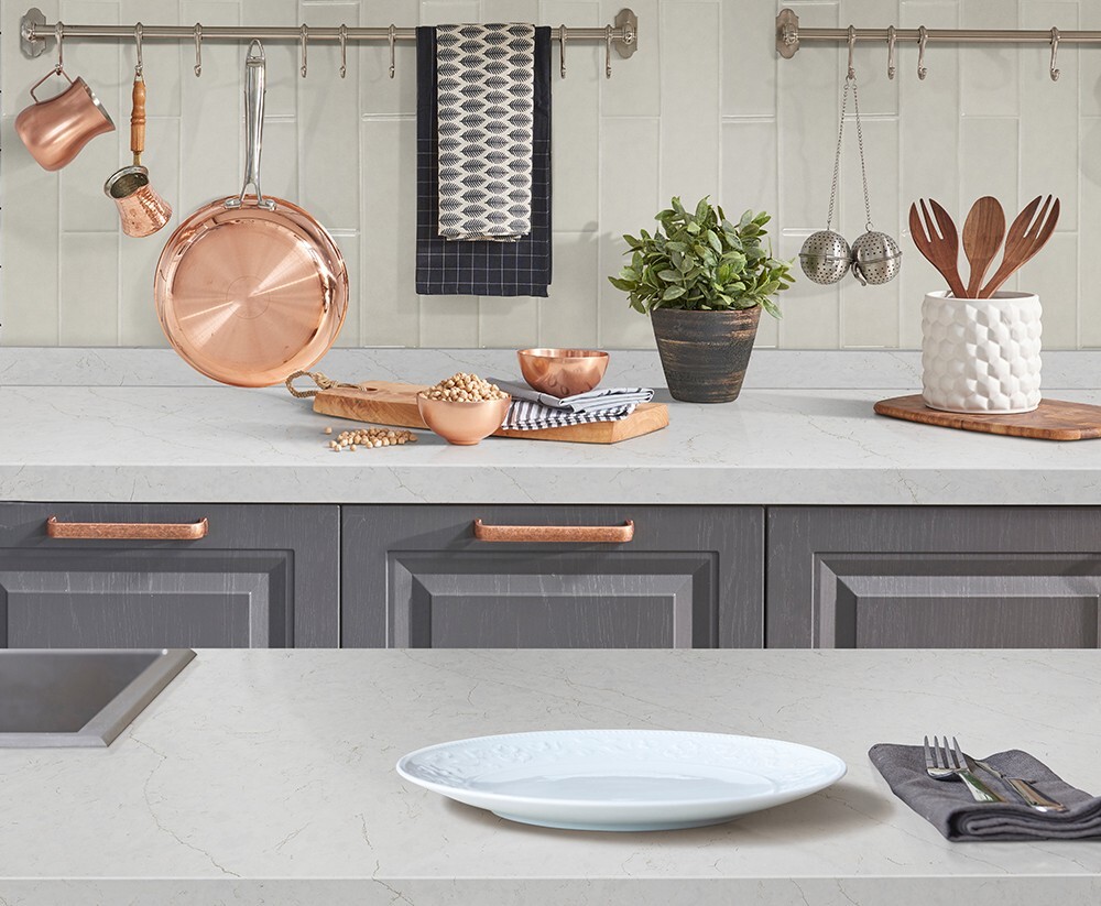 White subway tile backsplash with gray cabinets and copper accents, showcasing a classic and easy-to-maintain kitchen backsplash.