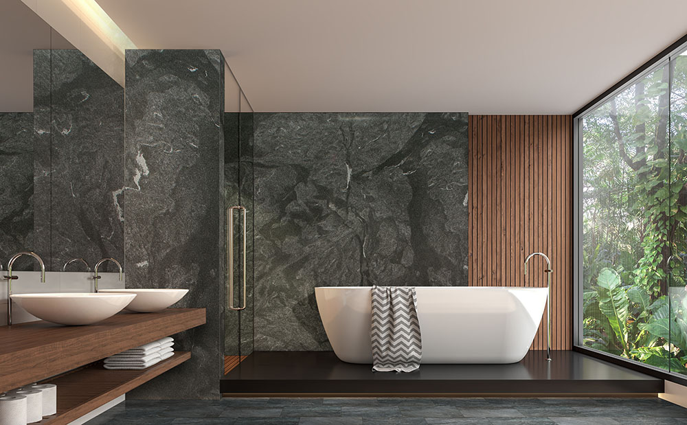 Luxury bathroom with full height granite slab walls and bathtub surround. Shows granite countertop thickness beyond worktops.