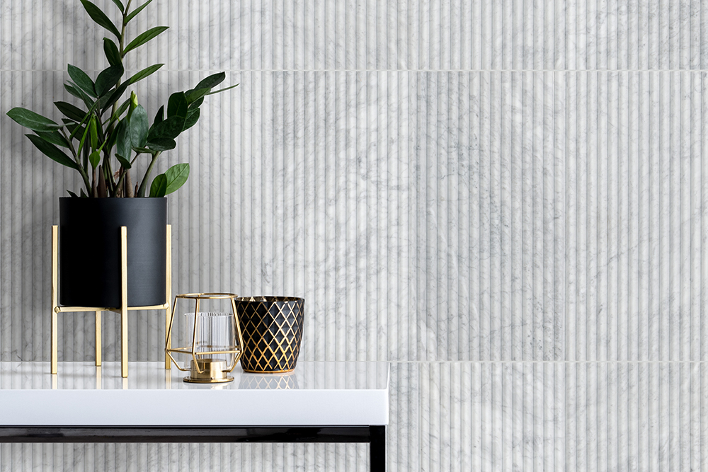 White fluted tile with vertical grooves and soft shadowing to create textured accent wall.