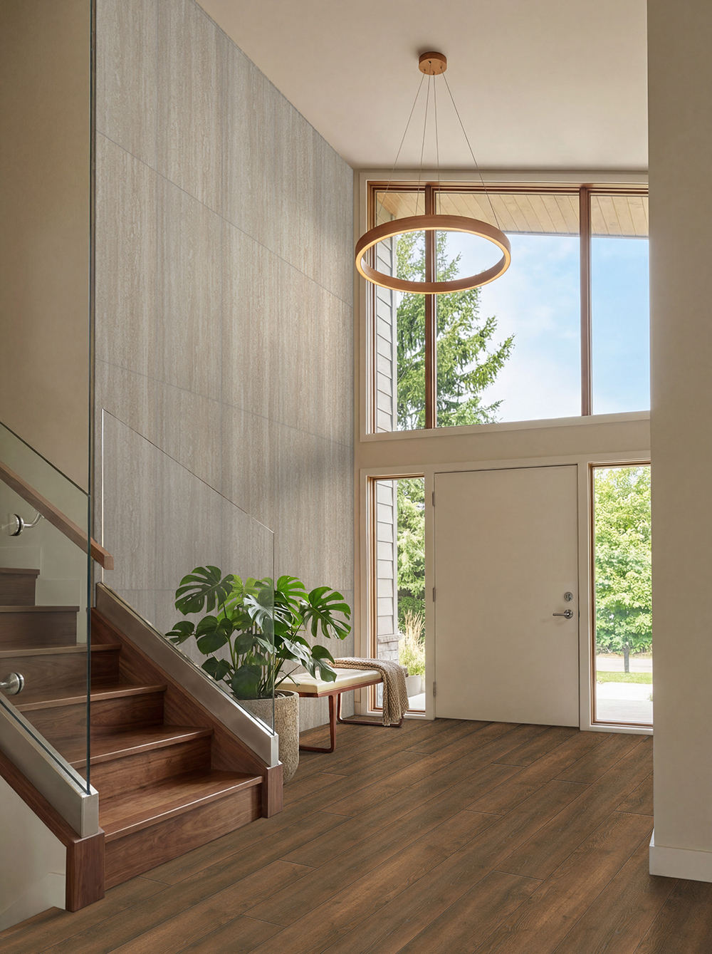Large entryway with wood stairs and floor to ceiling windows with warm brown waterproof hybrid rigid core flooring.