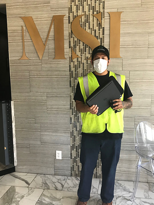 Man standing with a laptop at MSI Charitable Trust