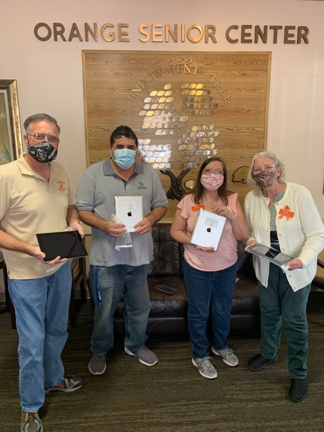 Group of people with donated iPads at Orange Senior Center