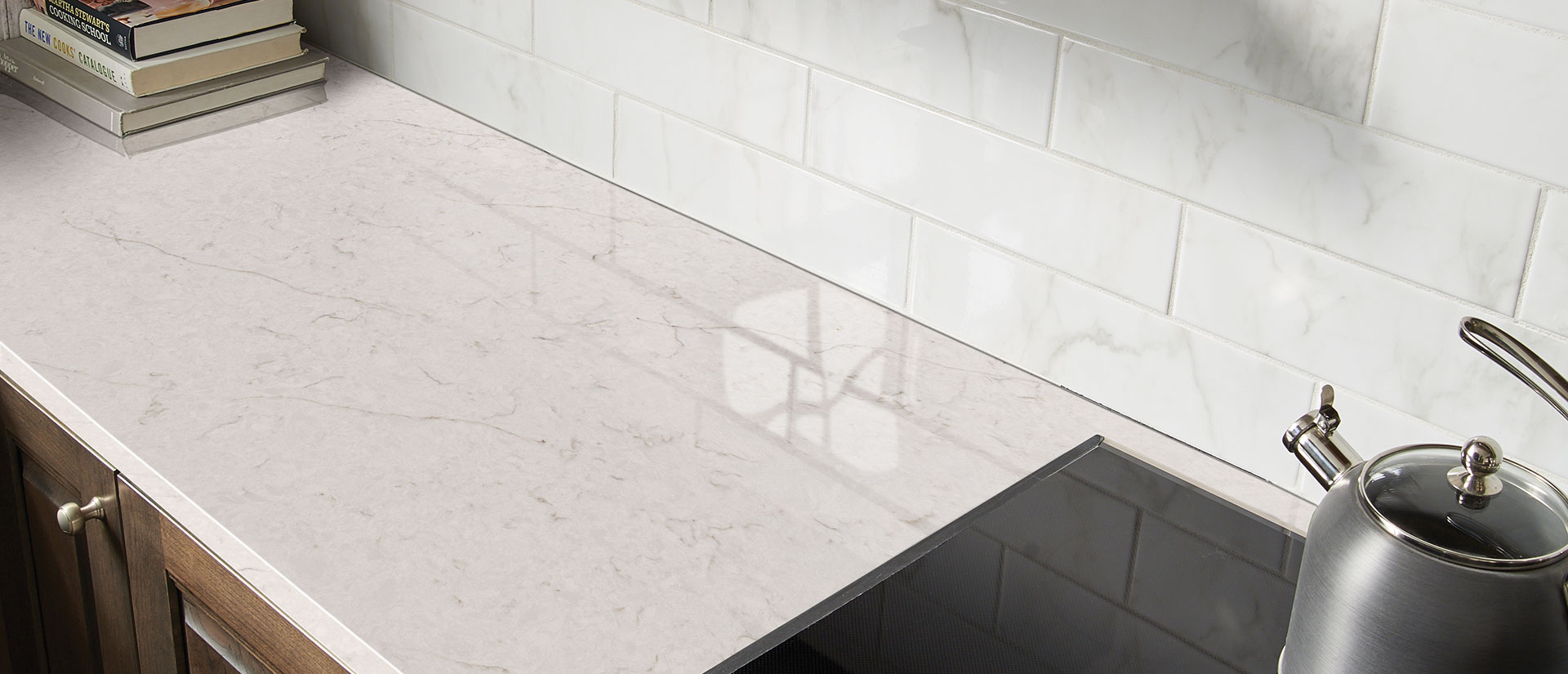 Carrara Caldia quartz countertop in a luxurious kitchen with marble backsplash