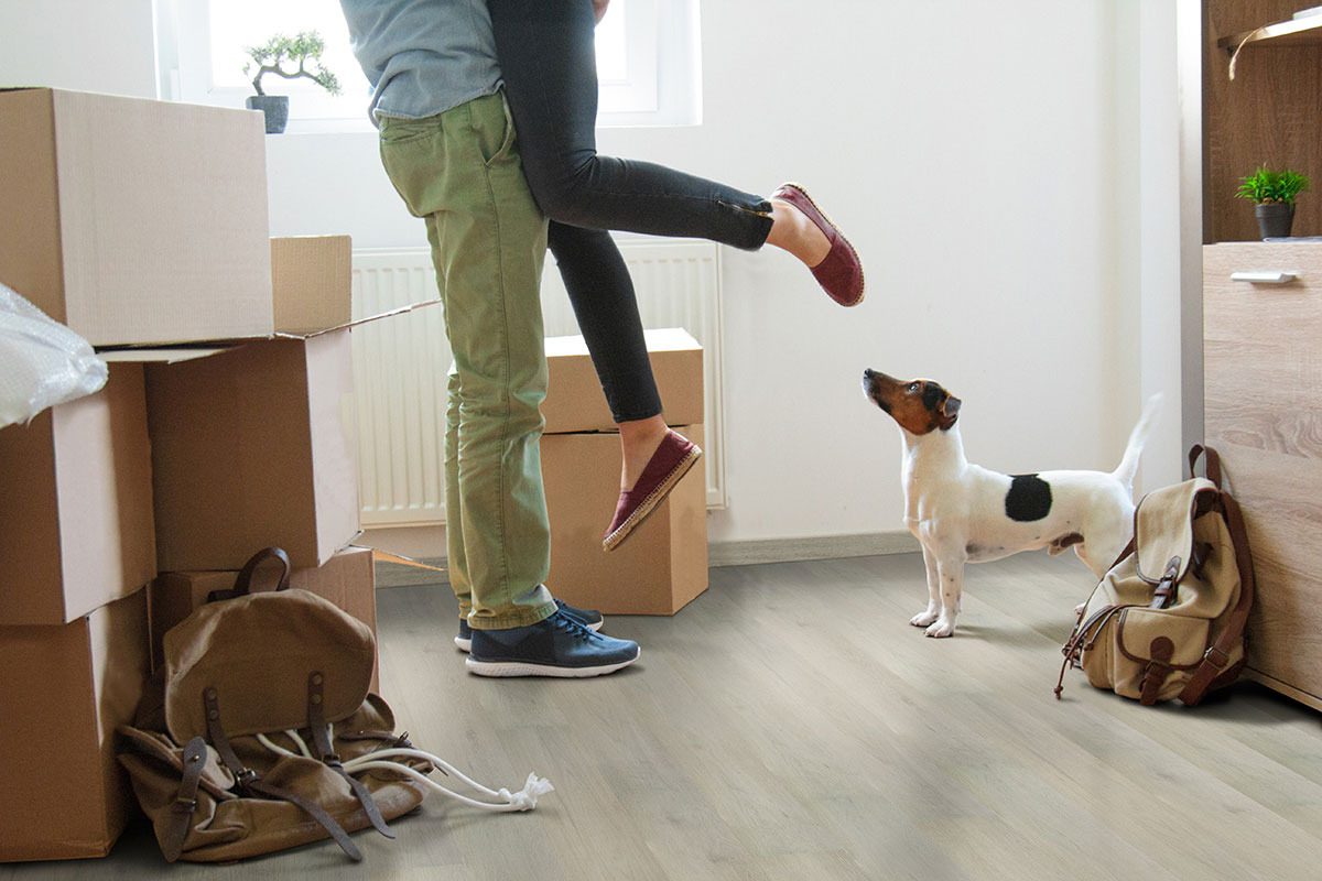 Couple with dog celebrating new home with Driftway Hybrid Rigid Core Flooring
