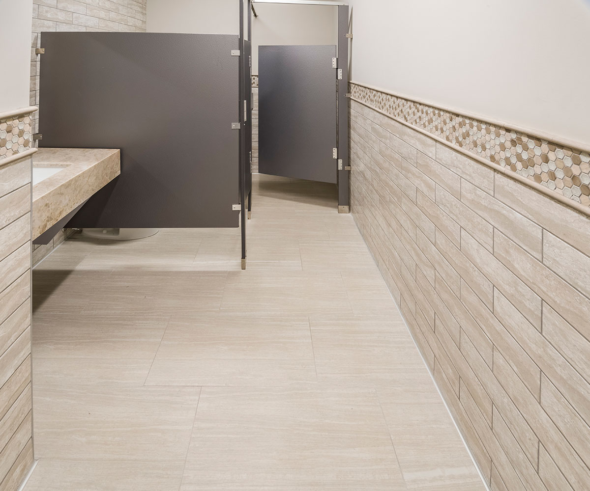 Gris Travertine Subway Tile and Orion Pietra Porcelain used in a commercial bathroom